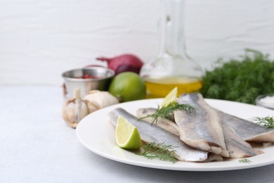 Marinated herring fillets with lime and dill on grey table, closeup. Space for text