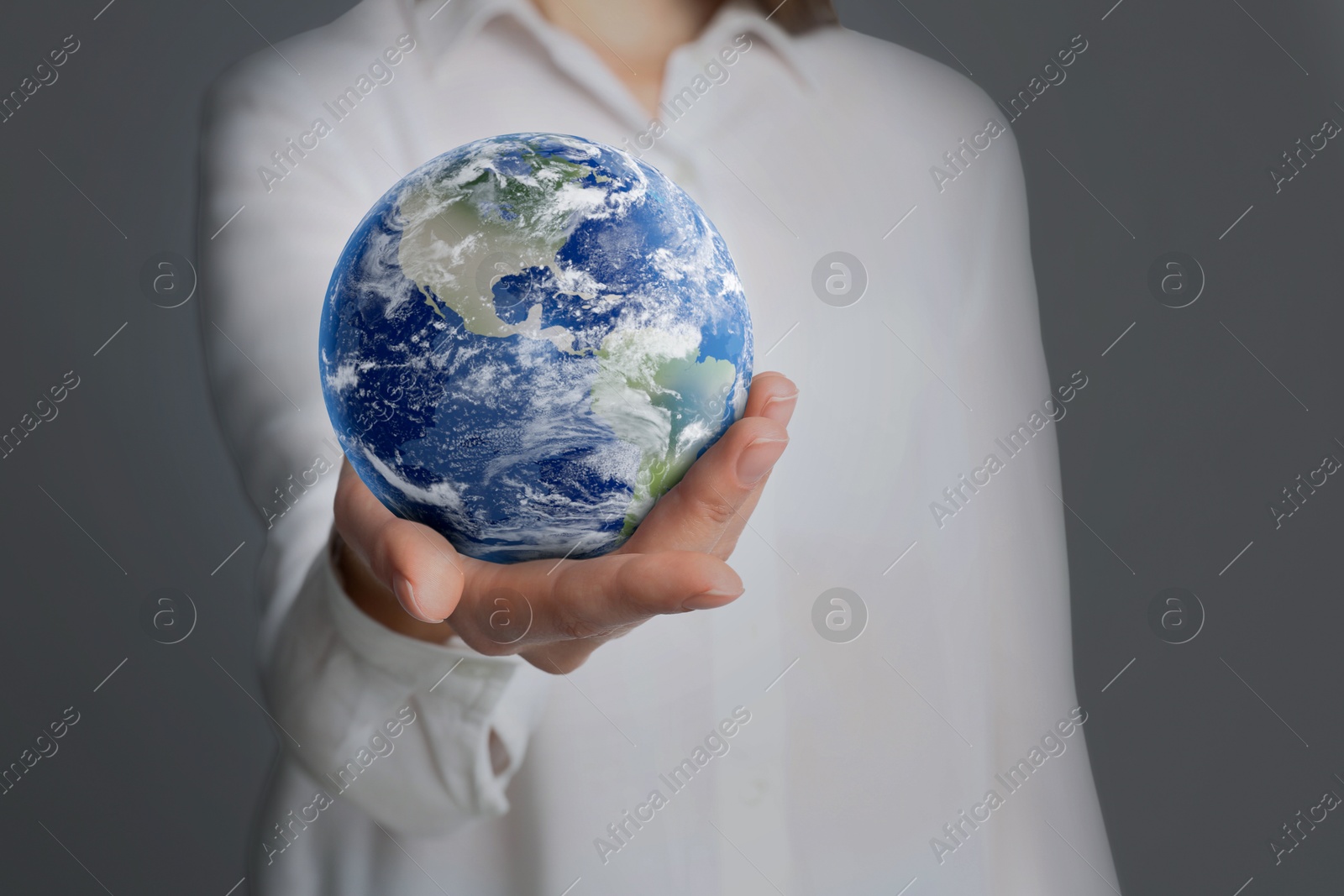 Image of Planet in our hands. Woman holding Earth model on grey background, closeup