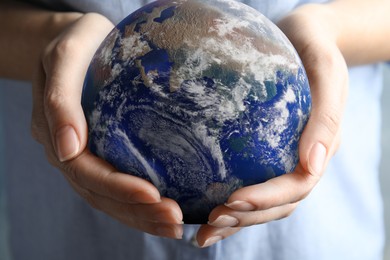 Image of Planet in our hands. Woman holding Earth model, closeup