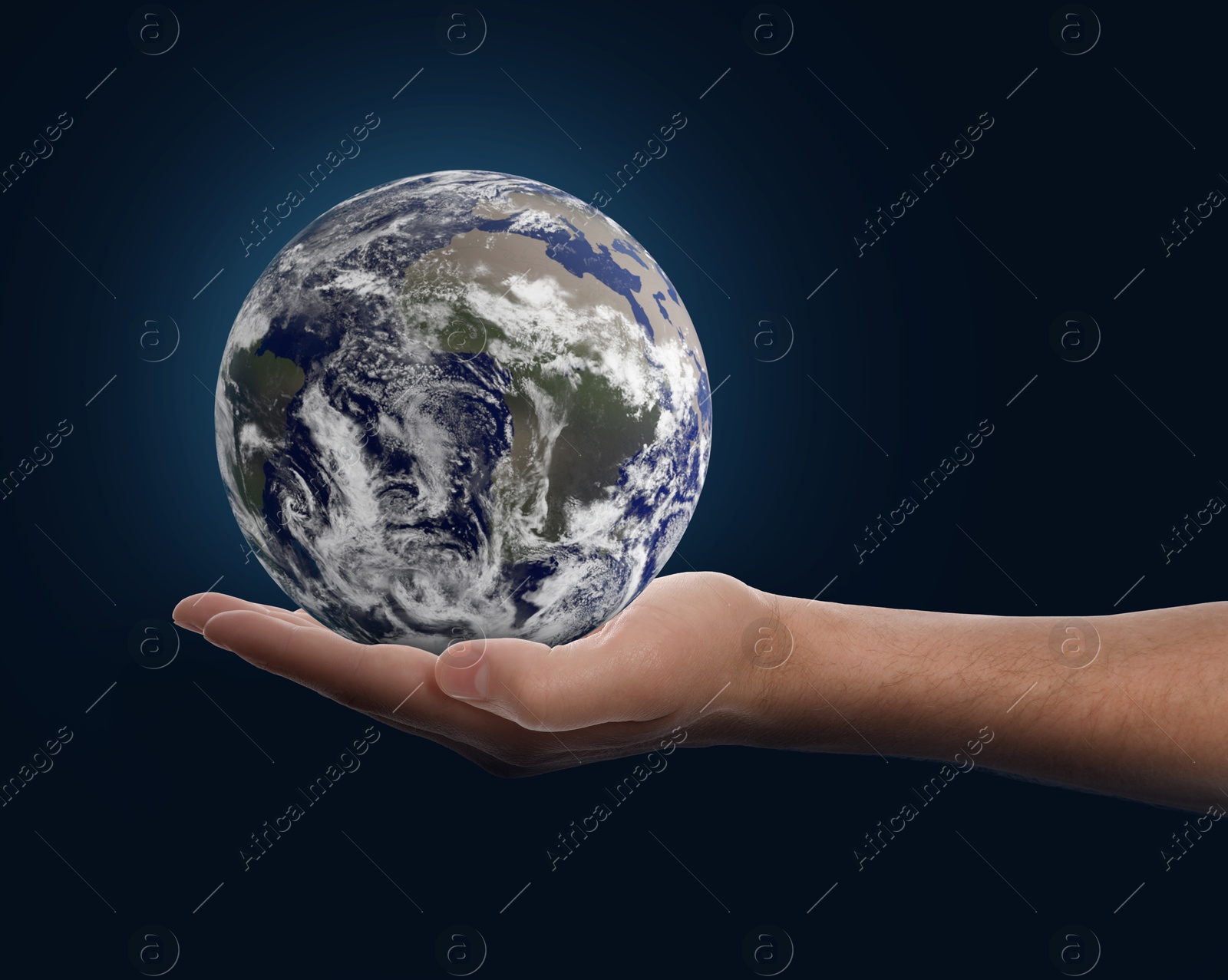 Image of Planet in our hands. Man holding Earth model on dark blue background, closeup