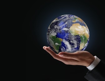 Image of Planet in our hands. Man holding glowing Earth on black background, closeup. Space for text