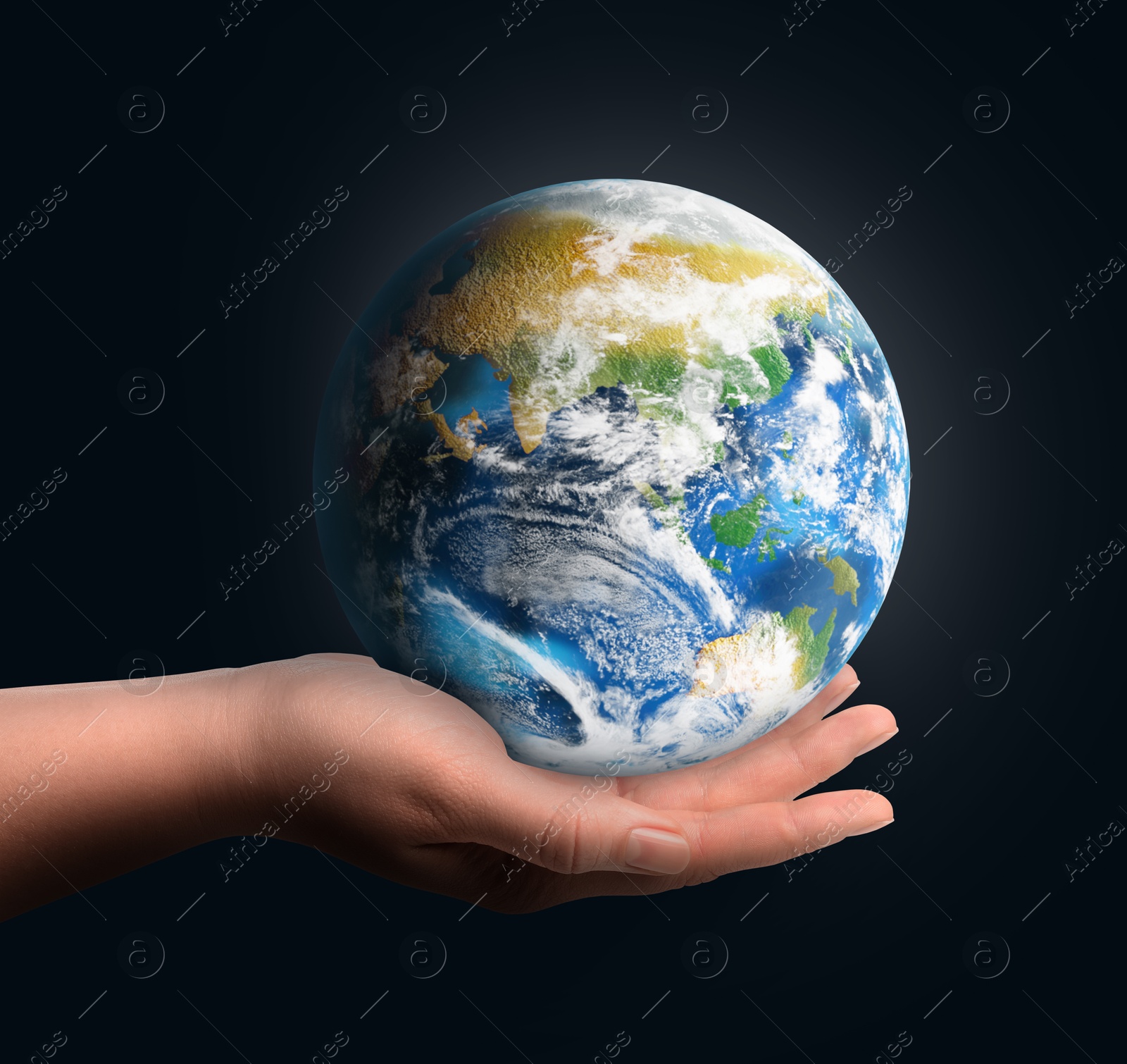 Image of Planet in our hands. Woman holding glowing Earth on dark blue background, closeup