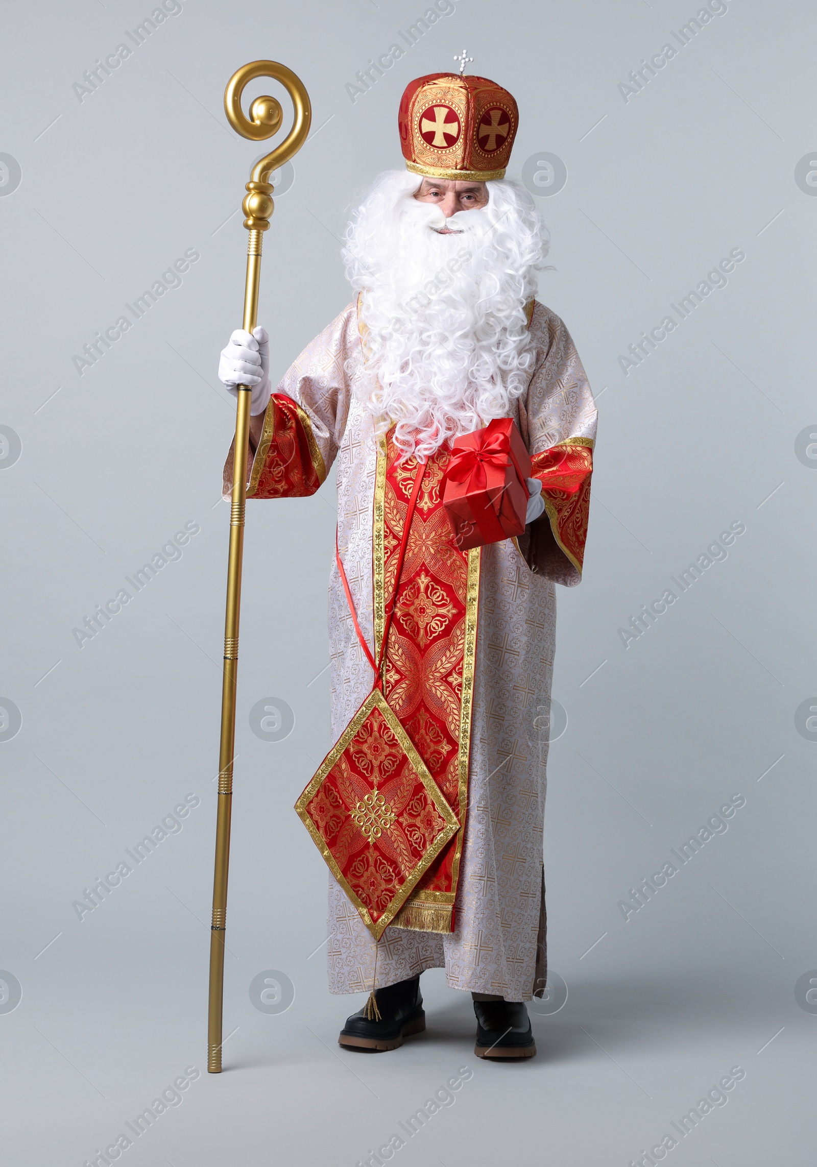 Photo of Saint Nicholas with gift on light grey background