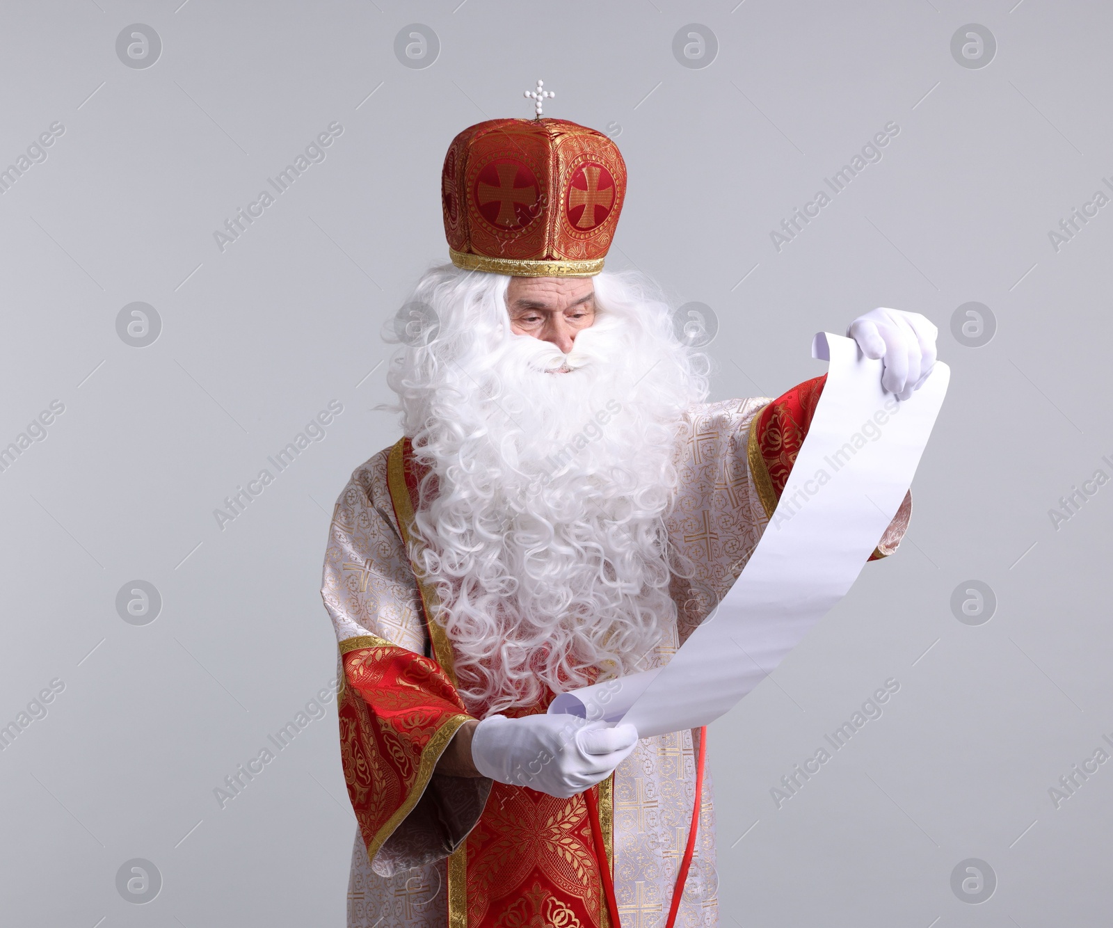 Photo of Saint Nicholas with gift list on light grey background