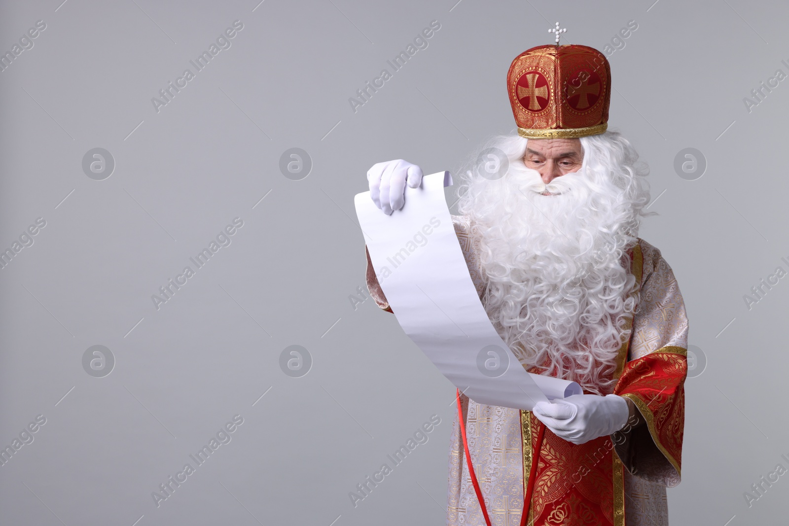 Photo of Saint Nicholas with gift list on light grey background. Space for text