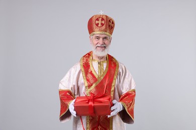 Saint Nicholas with gift on light grey background