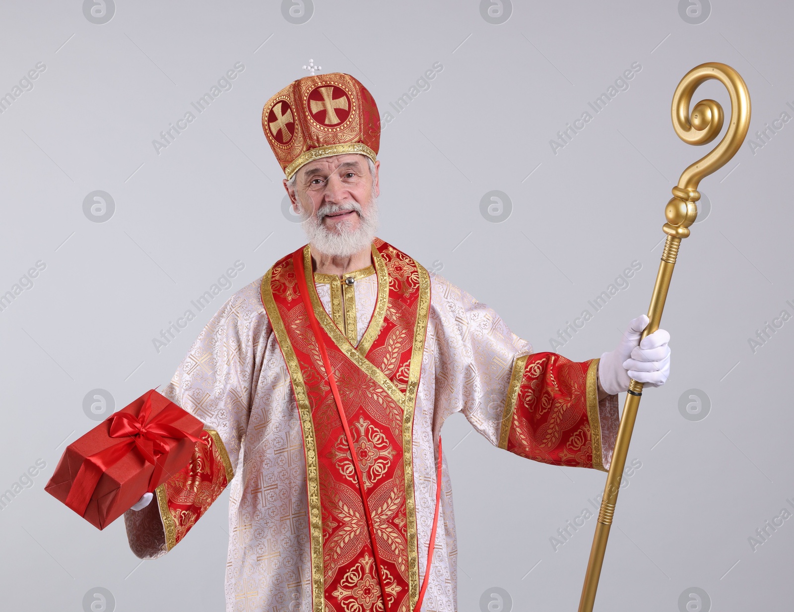 Photo of Saint Nicholas with gift on light grey background