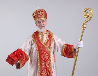 Photo of Saint Nicholas with gift on light grey background