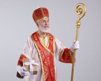 Photo of Saint Nicholas with gift on light grey background