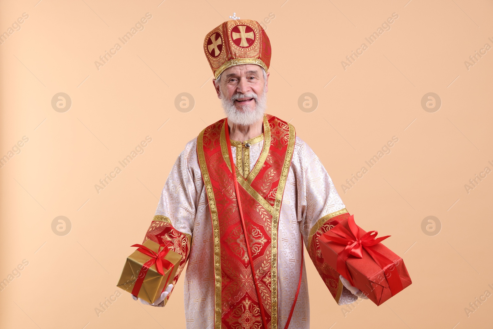 Photo of Saint Nicholas with gifts on beige background