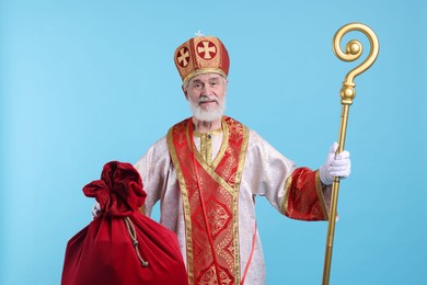 Photo of Saint Nicholas with sack on light blue background