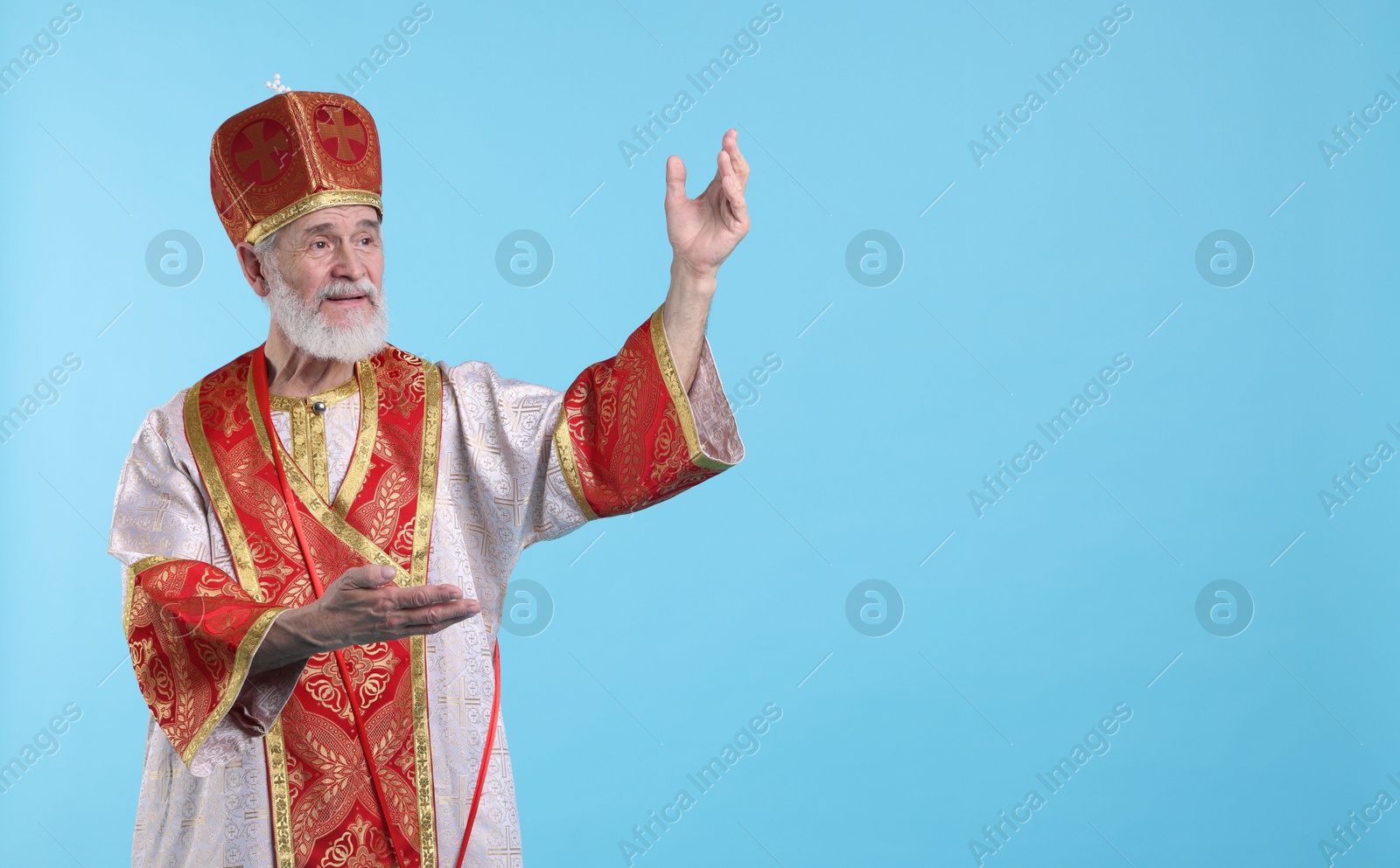 Photo of Saint Nicholas on light blue background. Space for text