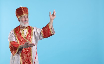 Photo of Saint Nicholas on light blue background. Space for text