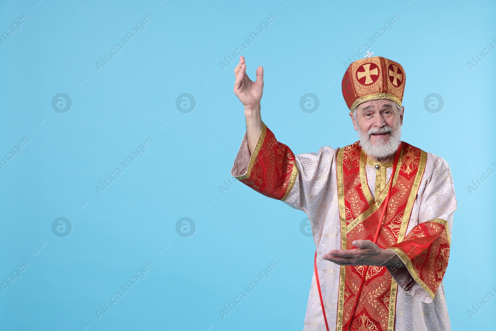 Photo of Saint Nicholas on light blue background. Space for text