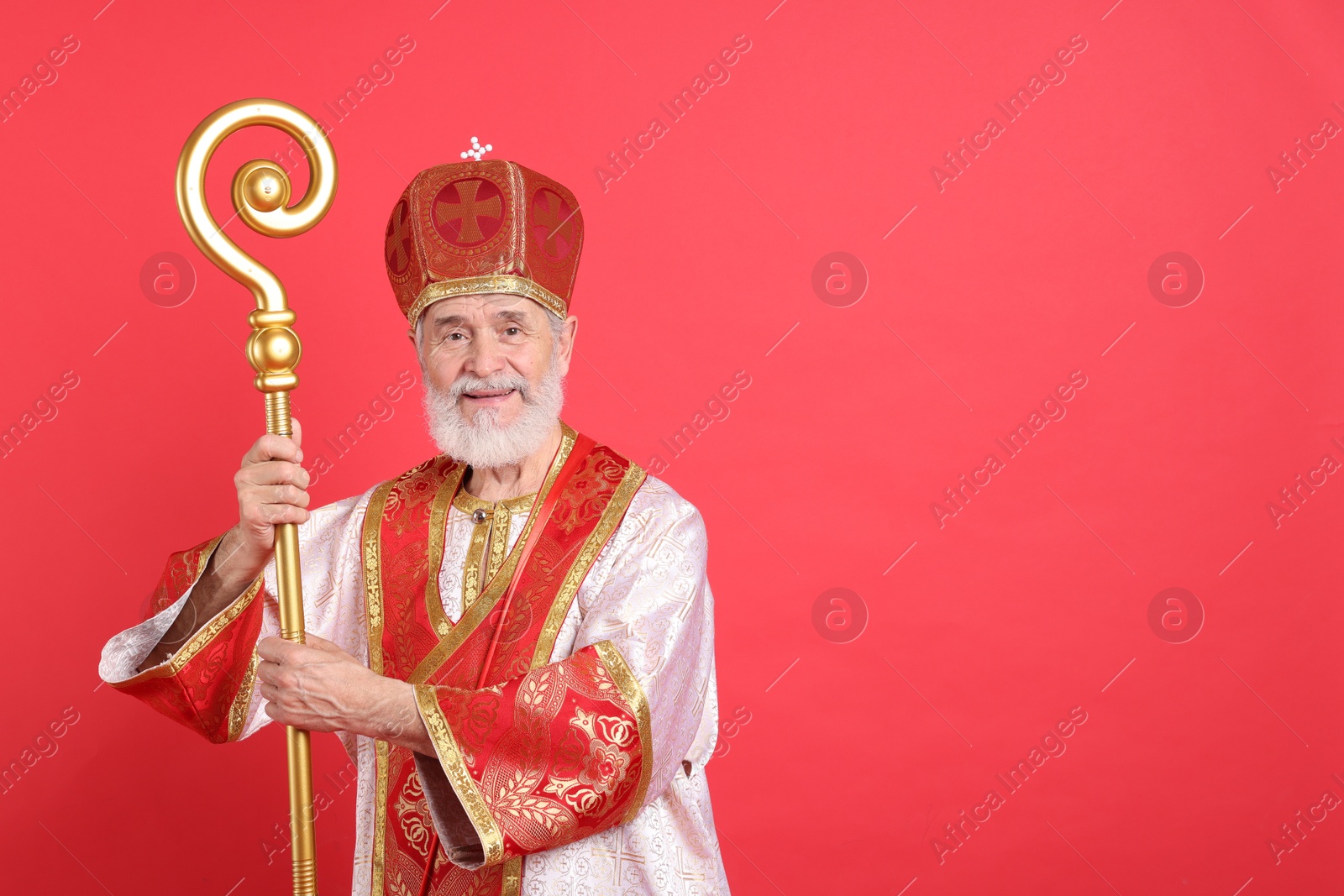 Photo of Saint Nicholas with crozier on red background. Space for text