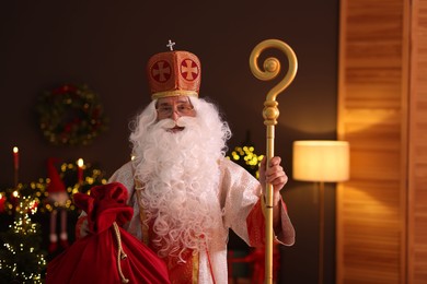 Photo of Saint Nicholas with sack in room decorated for Christmas