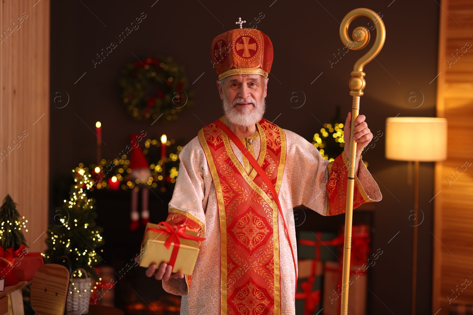 Photo of Saint Nicholas with gift in room decorated for Christmas