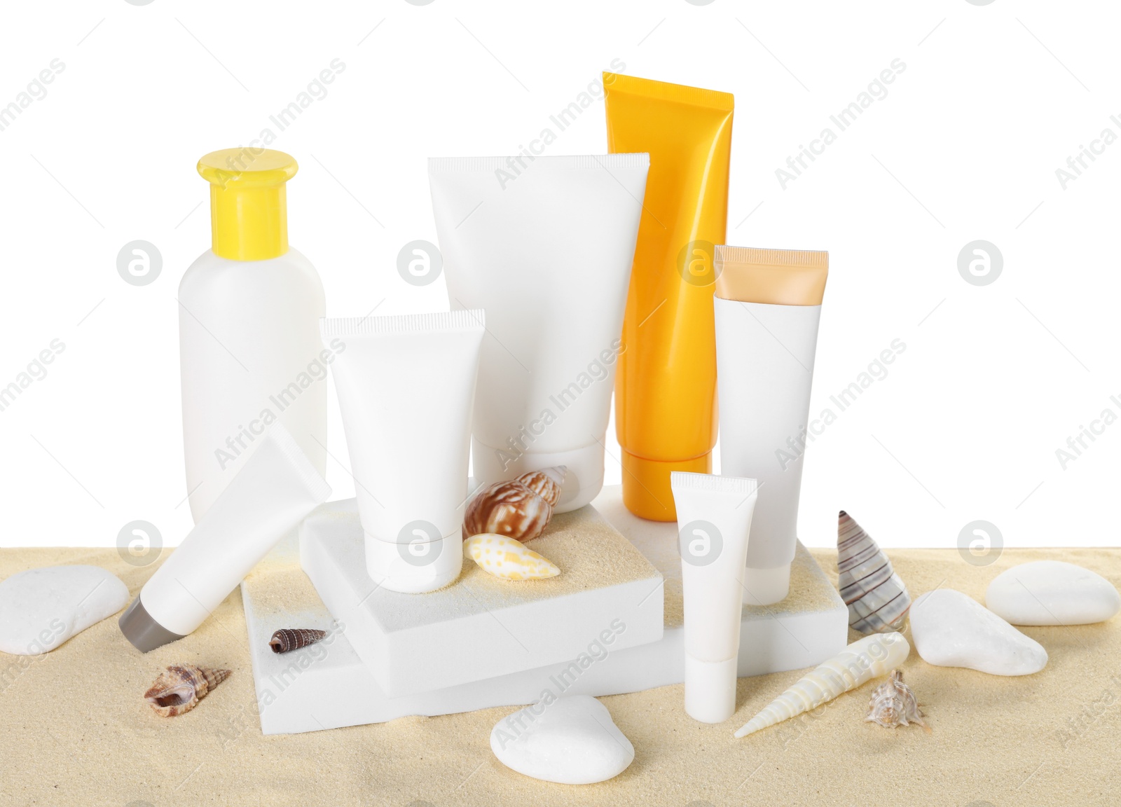 Photo of Different sun protection products and seashells on sand against white background