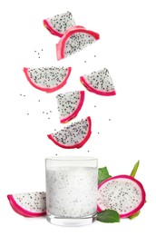 Image of Tasty pitahaya fruit pieces in air over glass of fresh smoothie on white background