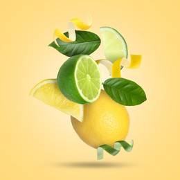 Image of Lemon, lime, zest and green leaves in air on golden background