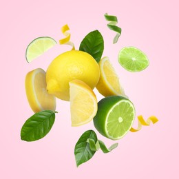 Image of Lemon, lime, zest and green leaves in air on pink background