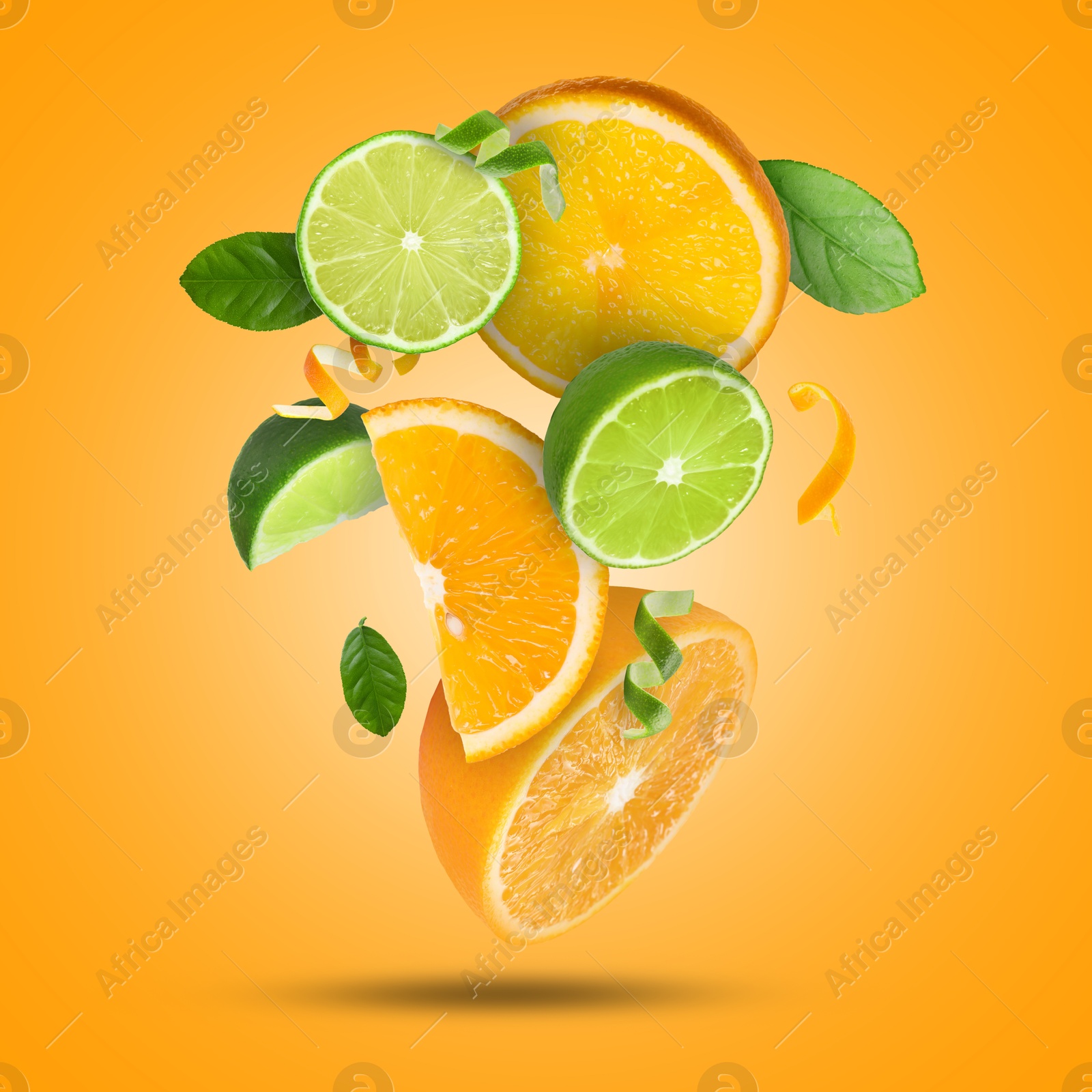 Image of Lime, orange, zest and green leaves in air on orange background