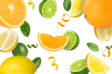 Image of Limes, lemons, oranges, zest and green leaves in air on white background