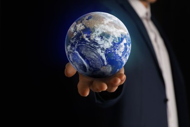 Image of Planet in our hands. Man holding Earth model on black background, closeup