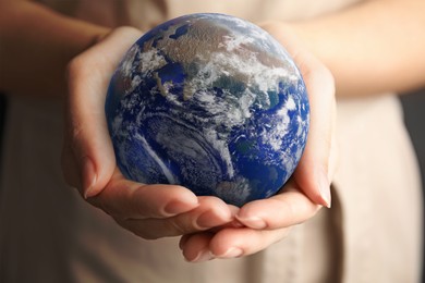 Image of Planet in our hands. Woman holding Earth model, closeup