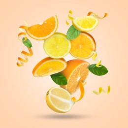 Image of Lemon, orange, zest and green leaves in air on pink beige background