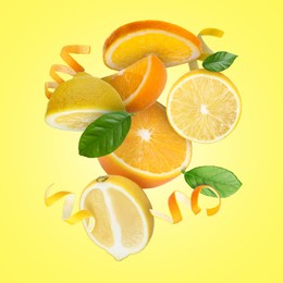 Image of Lemon, orange, zest and green leaves in air on yellow background