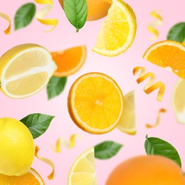 Image of Lemons, oranges, zest and green leaves in air on pink background