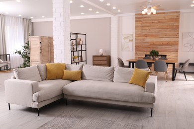 Photo of Stylish living room interior with comfortable sofa and wooden table