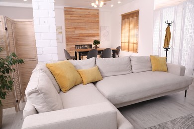 Photo of Stylish living room interior with comfortable sofa and wooden table