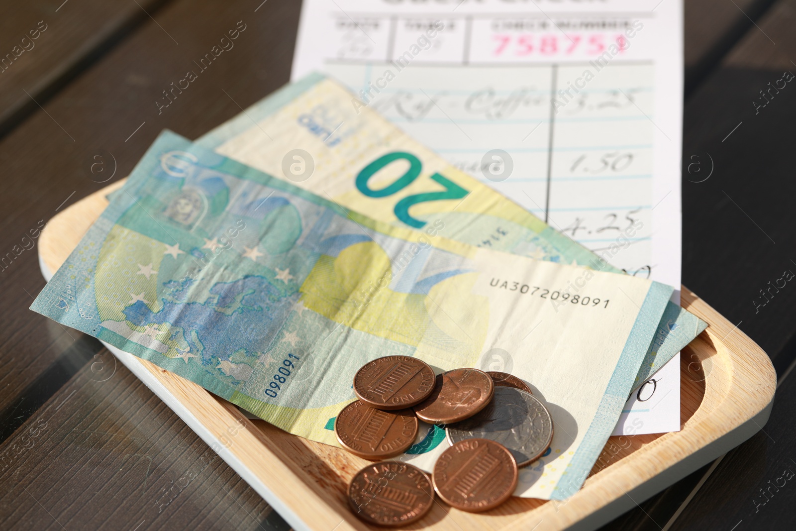 Photo of Wooden plate with payment for order and receipt on table, closeup. Leave tip