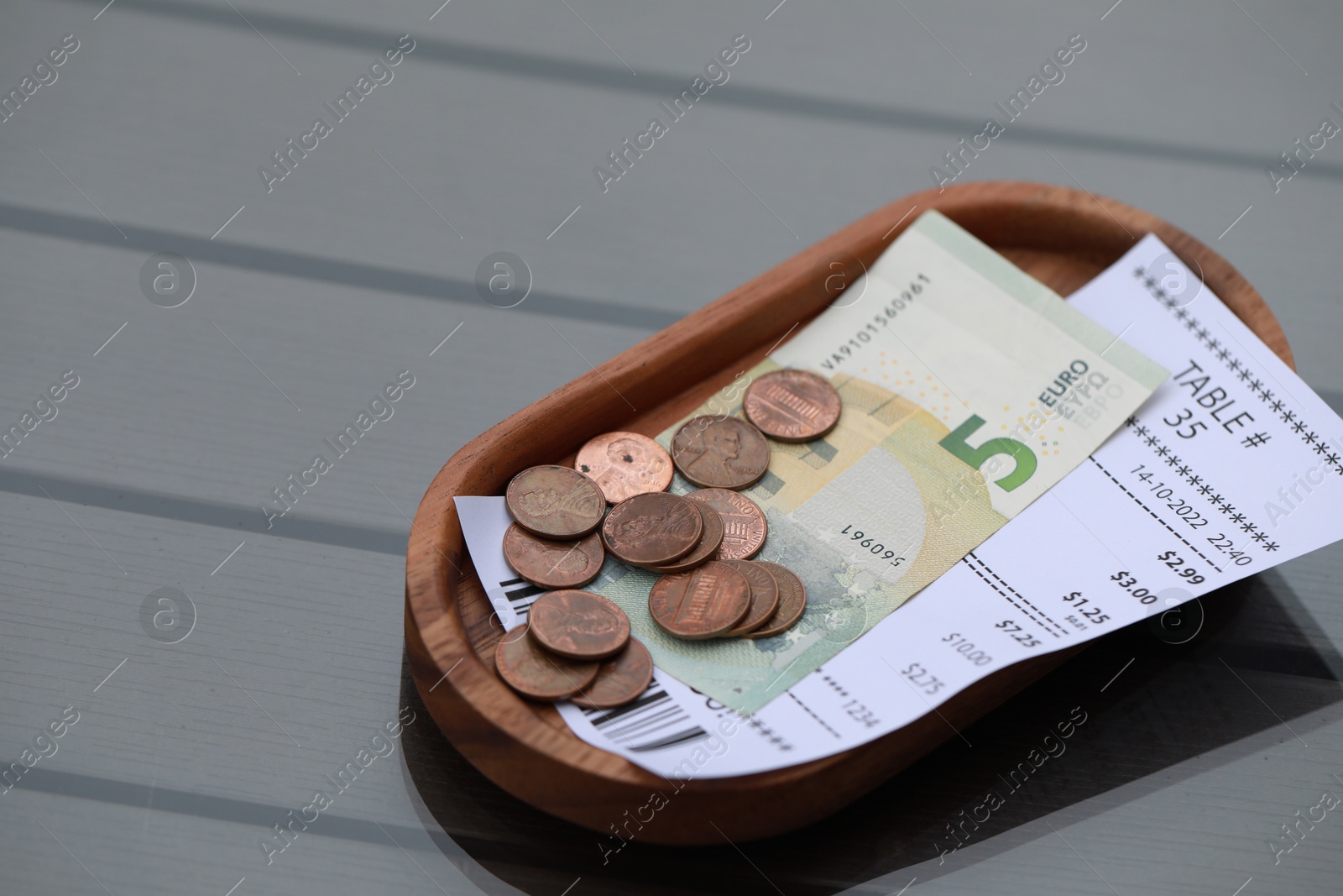 Photo of Tip and receipt on wooden table, space for text