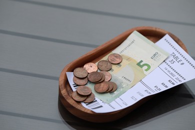 Photo of Tip and receipt on wooden table, space for text