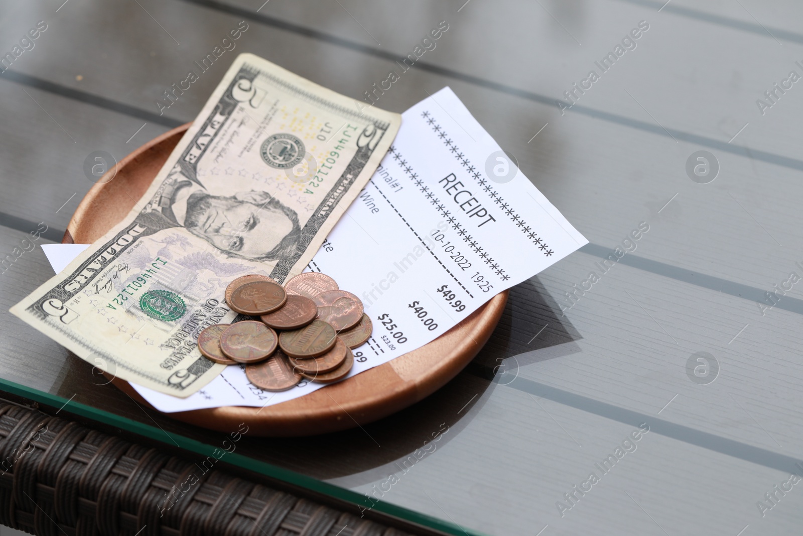 Photo of Tip and receipt on wooden table in cafeteria