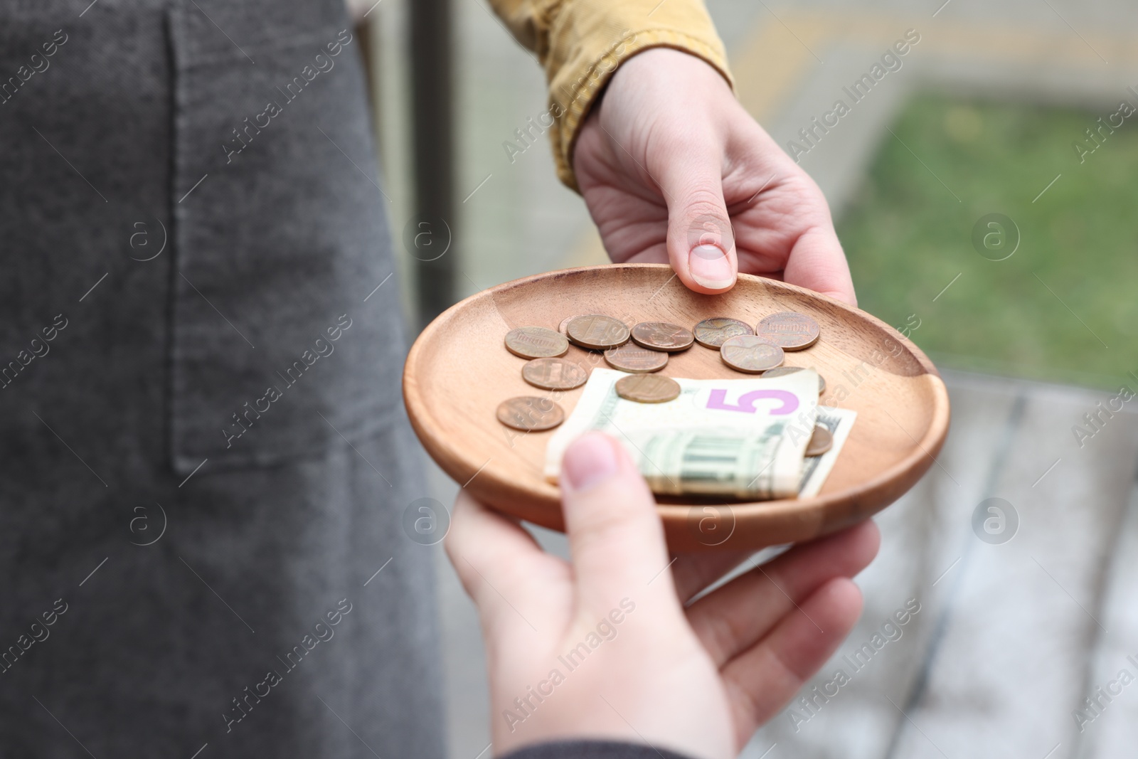 Photo of Client giving tips to waitress in outdoor cafe, closeup