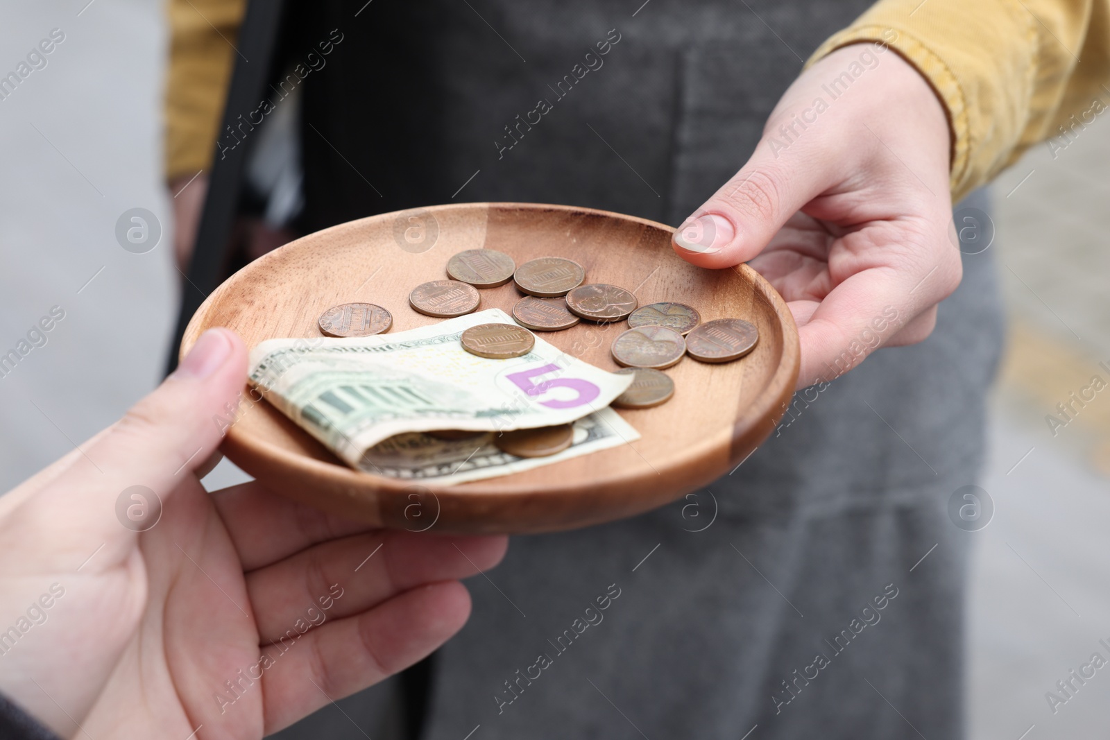 Photo of Client giving tips to waitress in outdoor cafe, closeup