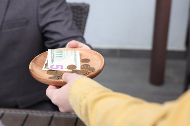 Photo of Client giving tips to waitress in outdoor cafe, closeup