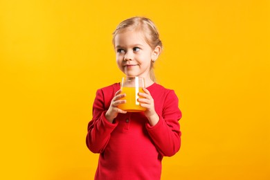 Photo of Girl with glass of juice on orange background. Refreshing drink