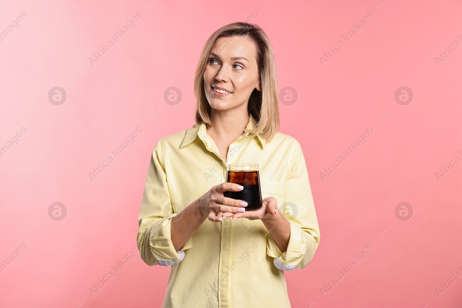 Photo of Woman with glass of refreshing soda drink on pink background