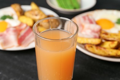 Photo of Tasty brunch. Refreshing drink and dishes on dark table, closeup