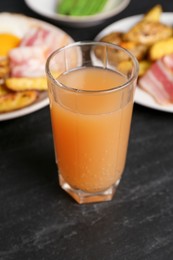 Photo of Tasty brunch. Refreshing drink and dishes on dark textured table, closeup