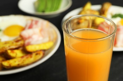 Photo of Tasty brunch. Refreshing drink and dishes on dark table, closeup