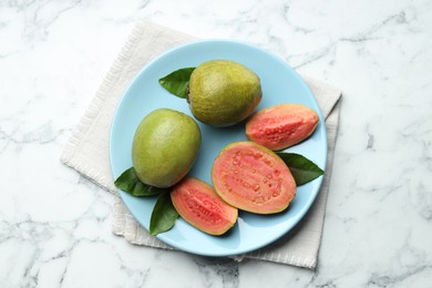 Photo of Fresh guava fruits and leaves on white marble table, top view