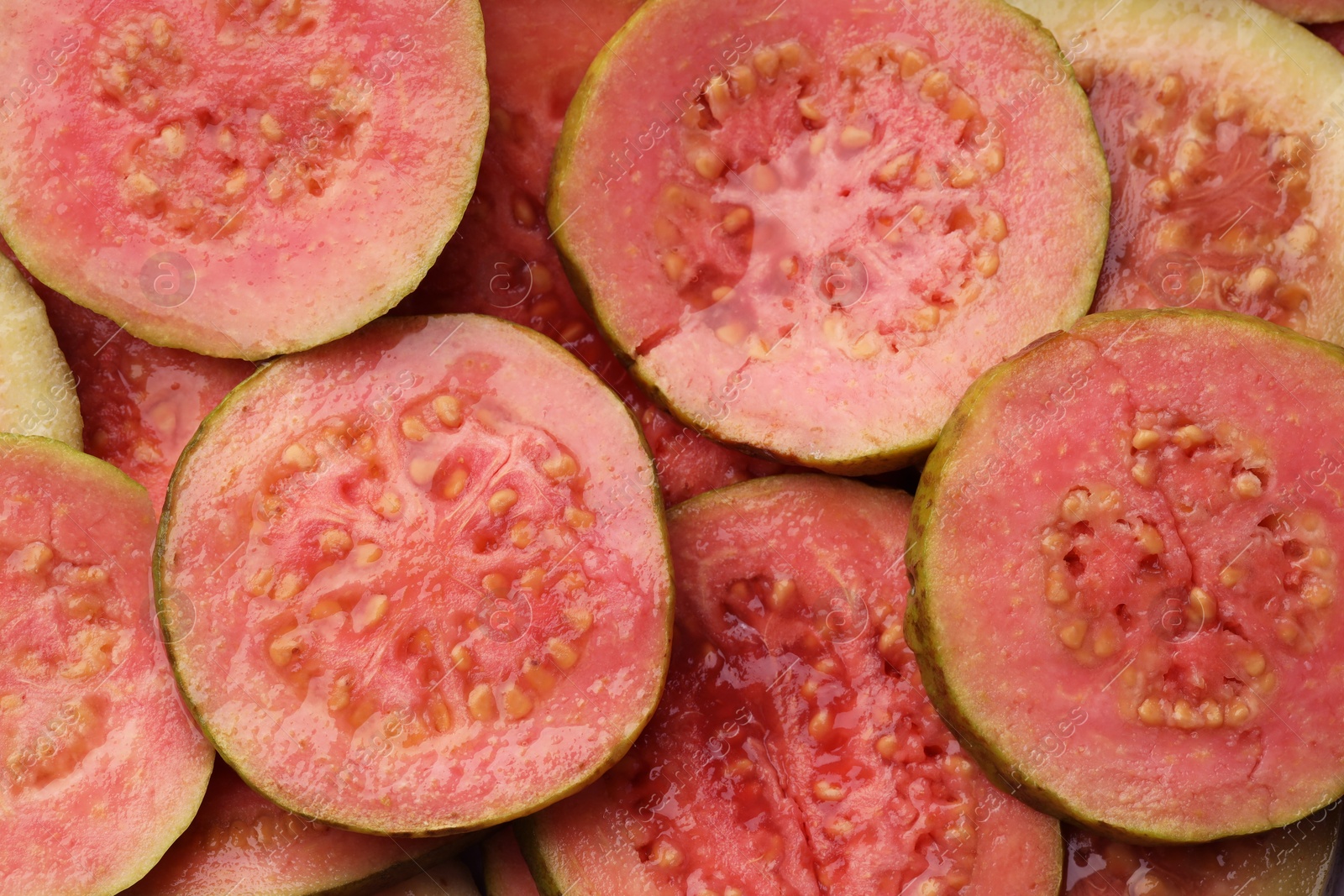 Photo of Many juicy slices of guava as background, top view