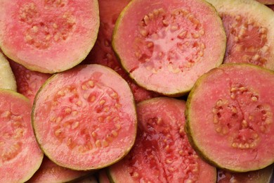 Photo of Many juicy slices of guava as background, top view