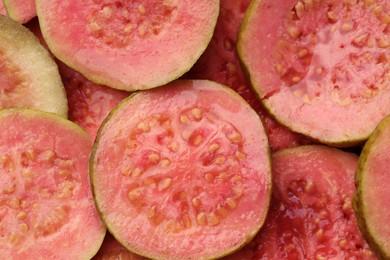 Photo of Many juicy slices of guava as background, top view